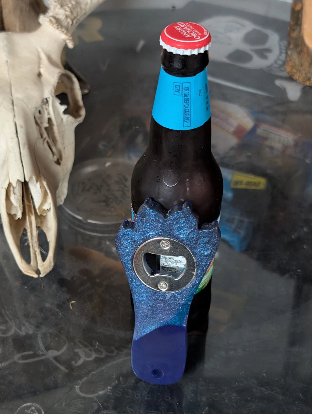 Hand crafted resin paw print bottle opener with magnet. blue and purple in color. other colors available